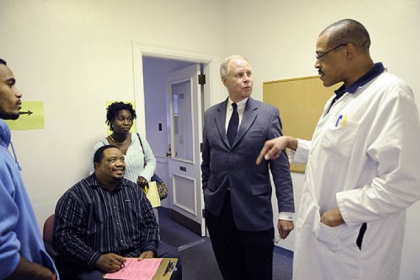 Dr. Dixon, center, meets with nurse practioner Charles Timbers, right, and Dom Timbers, 18, left, his father William Timbers, and Desiree Polite as Dom gets his school vaccinations at the Allegheny County Health Department's Forbes Medical building in Oakland.